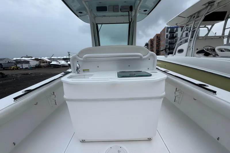 Slide: The Image of 2019 Everglades 273 Center Console boat interior with storage compartment, docked at marina. - 7