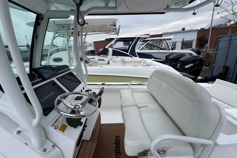 Slide: The Image of 2019 Everglades 273 Center Console boat interior with Garmin navigation and white seating. - 9