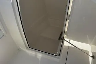 Slide: The Image of 2023 Cobia 220 Dual Console boat storage compartment, open hatch view. - 11