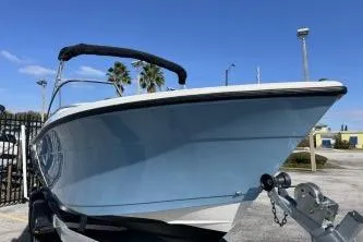 Slide: The Image of 2023 Cobia 220 Dual Console boat on trailer, blue hull, sunny day. - 3
