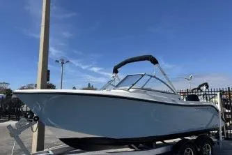 Slide: The Image of 2023 Cobia 220 Dual Console boat on trailer under clear blue sky. - 5