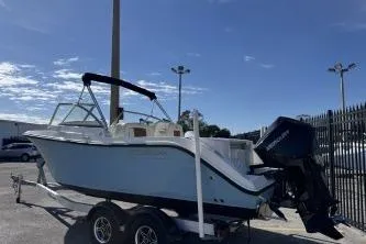 Slide: The Image of 2023 Cobia 220 Dual Console boat on trailer under clear blue sky. - 6