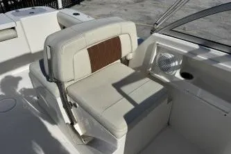 Slide: The Image of 2023 Cobia 220 Dual Console boat seat with beige upholstery and brown accent. - 9