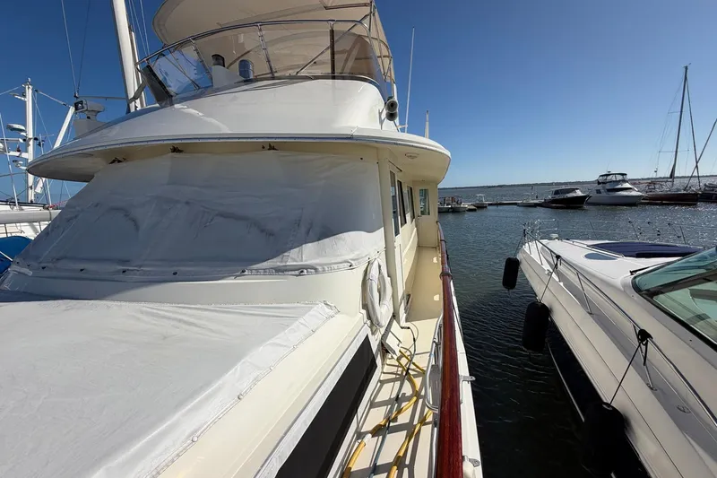 Slide: The Image of 1987 Hatteras 58 Motor Yacht docked at marina under clear blue sky. - 11