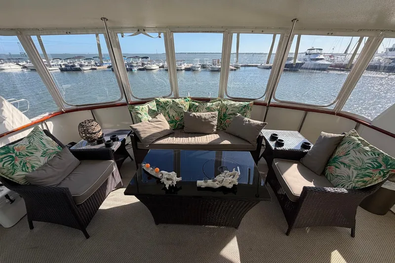 Slide: The Image of Luxurious 1987 Hatteras 58 Motor Yacht interior with elegant seating and marina view. - 15