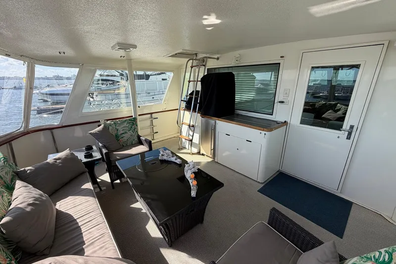 Slide: The Image of 1987 Hatteras 58 Motor Yacht interior with cozy seating and waterfront view. - 17