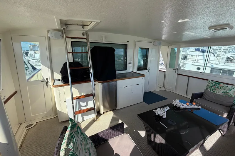Slide: The Image of Interior of 1987 Hatteras 58 Motor Yacht with seating, table, and ladder. - 18