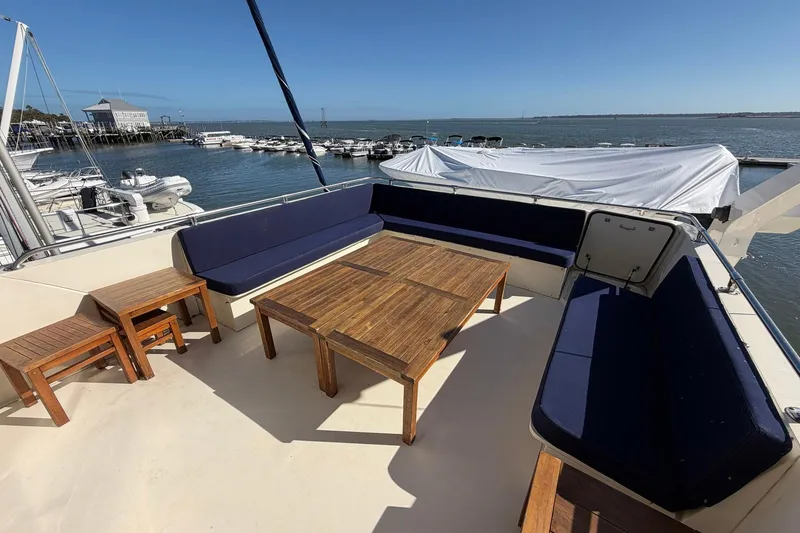 Slide: The Image of 1987 Hatteras 58 Motor Yacht deck with wooden furniture and ocean view. - 23