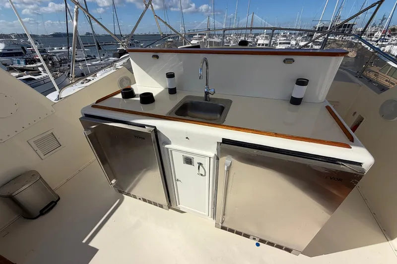 Slide: The Image of 1987 Hatteras 58 Motor Yacht outdoor kitchen with sink and stainless steel appliances. - 25