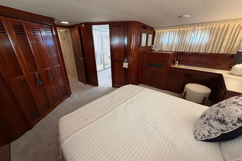 Slide: The Image of Luxurious 1987 Hatteras 58 Motor Yacht bedroom with elegant wood paneling and cozy decor. - 60
