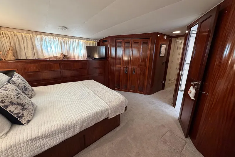 Slide: The Image of Luxurious bedroom interior of 1987 Hatteras 58 Motor Yacht with wood paneling and cozy bedding. - 61