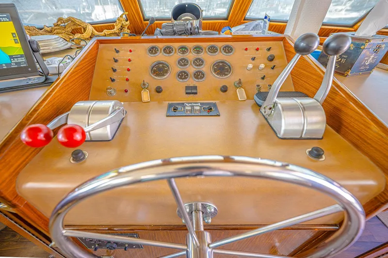 Slide: The Image of 1987 Hatteras 58 Motor Yacht helm with steering wheel and control panel. - 68