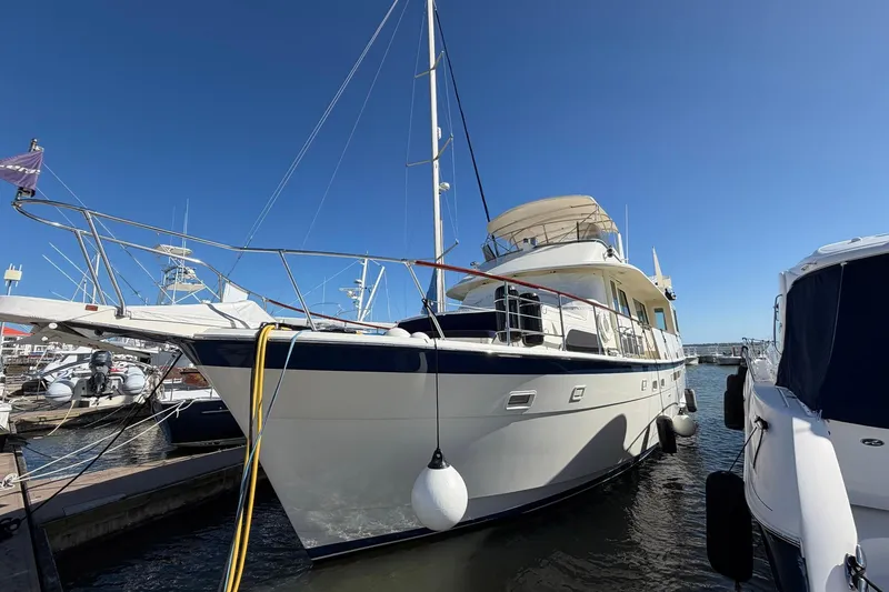Slide: The Image of 1987 Hatteras 58 Motor Yacht docked at marina under clear blue sky. - 7