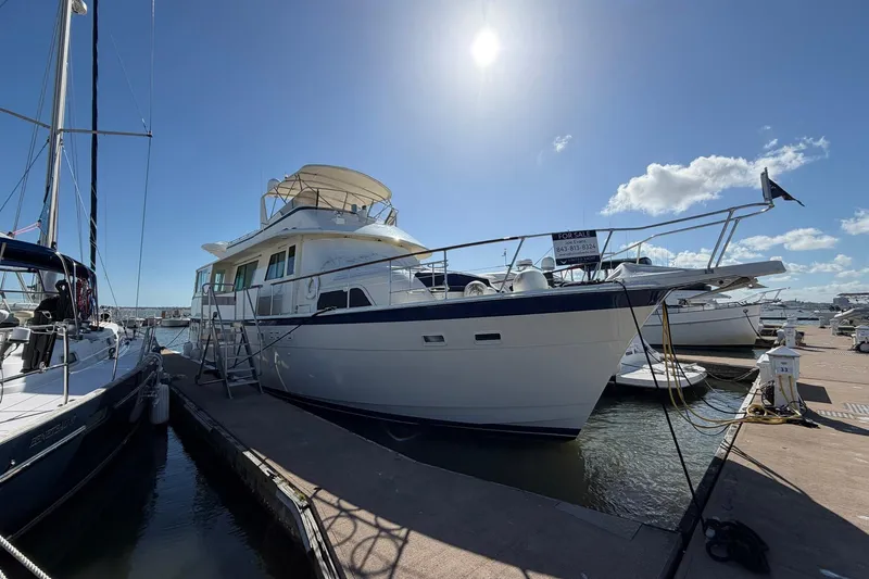 Slide: The Image of 1987 Hatteras 58 Motor Yacht docked under clear blue sky, for sale sign visible. - 8