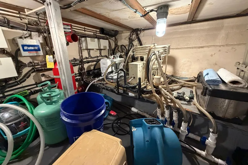 Slide: The Image of Engine room of 1987 Hatteras 58 Motor Yacht with equipment and storage items. - 80