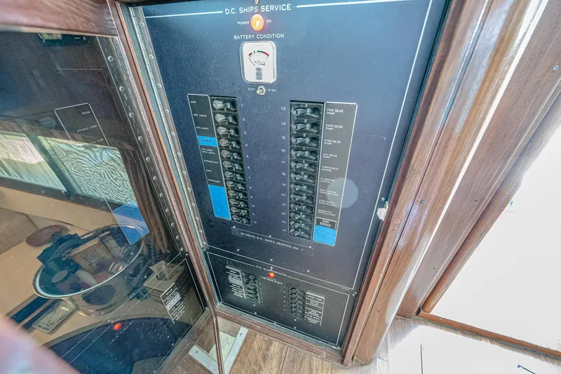 Slide: The Image of Electrical panel on 1987 Hatteras 58 Motor Yacht, showcasing circuit breakers and battery condition gauge. - 82