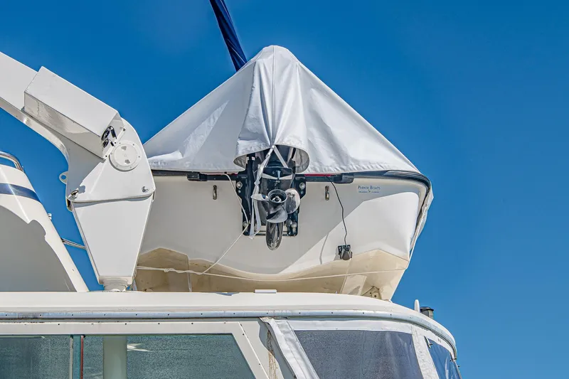 Slide: The Image of 1987 Hatteras 58 Motor Yacht with covered dinghy on deck against blue sky. - 85