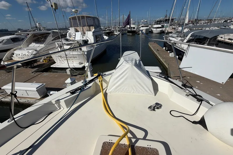 Slide: The Image of 1987 Hatteras 58 Motor Yacht docked at marina, surrounded by other boats. - 9
