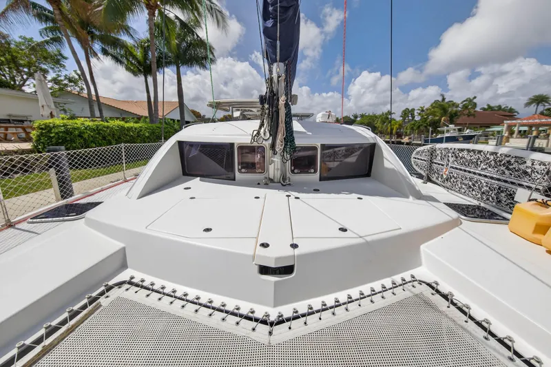 Slide: The Image of 2012 Leopard 39 catamaran deck with netting, docked near palm trees and blue sky. - 11