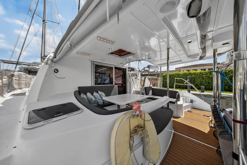 Slide: The Image of 2012 Leopard 39 yacht deck with seating, table, and life preserver, docked in a marina. - 12