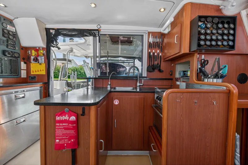 Slide: The Image of Modern kitchen interior of 2012 Leopard 39 yacht with wooden cabinetry and stainless steel appliances. - 25