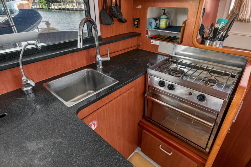Slide: The Image of Galley kitchen in 2012 Leopard 39 yacht with stove, sink, and utensils. - 26