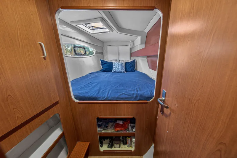 Slide: The Image of Cozy cabin interior of 2012 Leopard 39 yacht with blue bedding and wooden accents. - 33