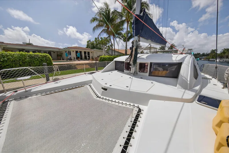 Slide: The Image of 2012 Leopard 39 catamaran docked near waterfront home, surrounded by palm trees. - 40