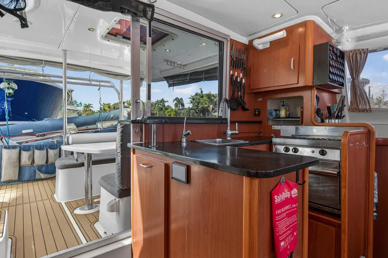 Slide: The Image of Interior of 2012 Leopard 39 yacht featuring kitchen and dining area with outdoor view. - 75