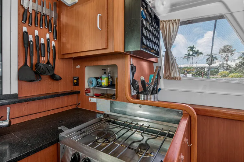 Slide: The Image of Compact kitchen in a 2012 Leopard 39 yacht with stove, utensils, and window view. - 77