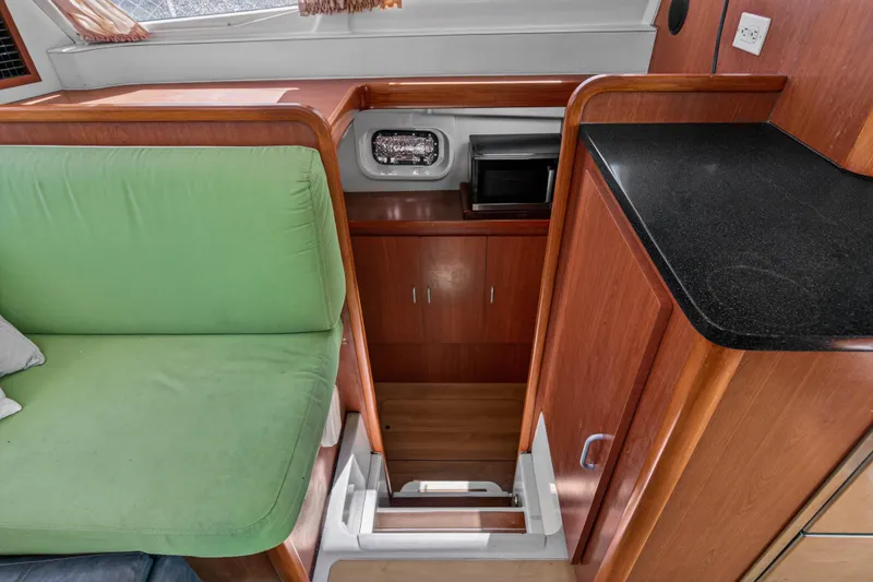 Slide: The Image of Interior of 2012 Leopard 39 yacht with green seating and wooden cabinetry. - 80