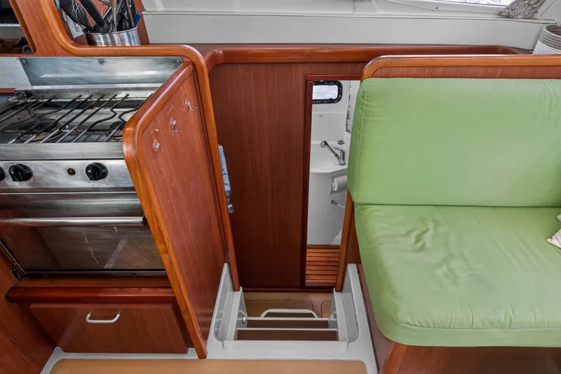 Slide: The Image of Interior of 2012 Leopard 39 yacht with green seating and compact kitchen area. - 81