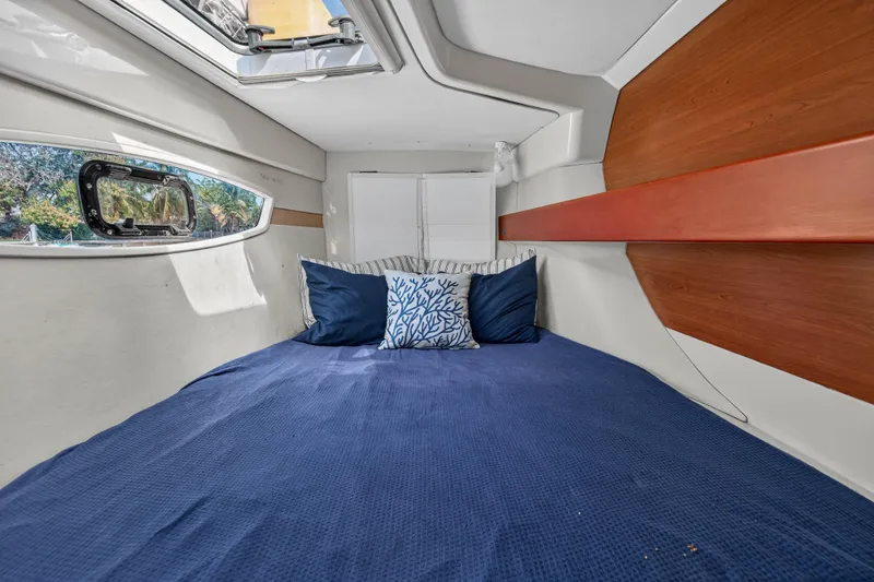Slide: The Image of Cozy cabin interior of 2012 Leopard 39 yacht with blue bedding and decorative pillows. - 89