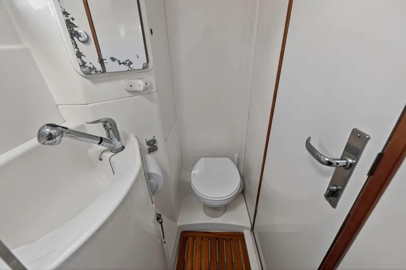 Slide: The Image of Compact bathroom in a 2012 Leopard 39 yacht, featuring a toilet, sink, and mirror. - 92