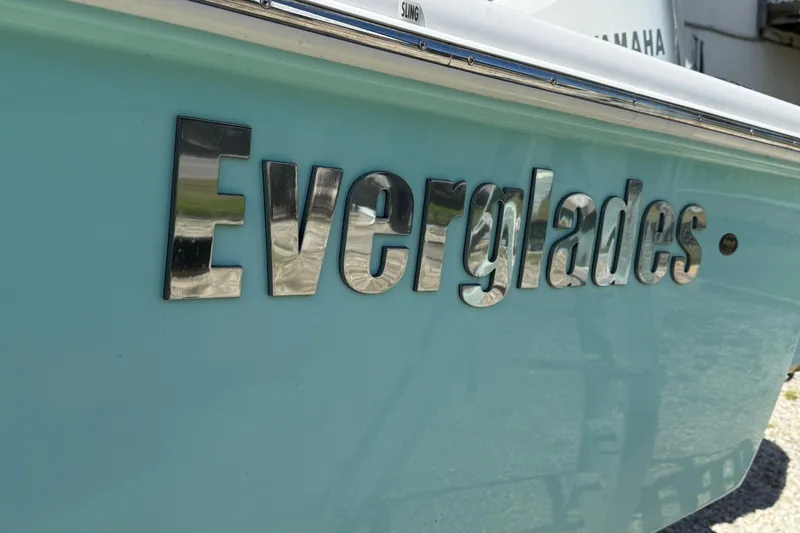 Slide: The Image of 2022 Everglades 273 Center Console boat with chrome logo on light blue hull. - 10