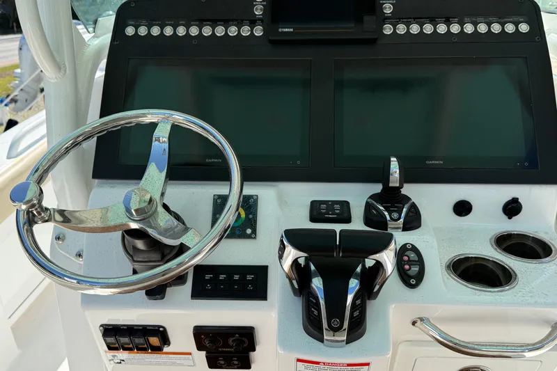 Slide: The Image of Center console of 2022 Everglades 273 boat with steering wheel and dual Garmin displays. - 11
