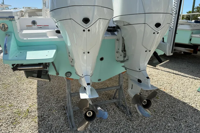 Slide: The Image of Twin outboard motors on a 2022 Everglades 273 Center Console boat, displayed on gravel. - 24