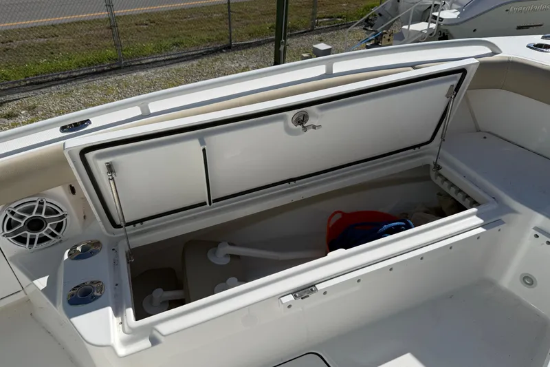 Slide: The Image of 2022 Everglades 273 Center Console boat storage compartment open, showing interior space. - 7