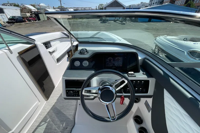 Slide: The Image of 2018 Regal 26 OBX boat dashboard with steering wheel and control panel. - 10