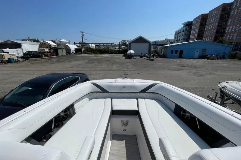 Slide: The Image of 2018 Regal 26 OBX boat with white seating, parked in a marina lot. - 15