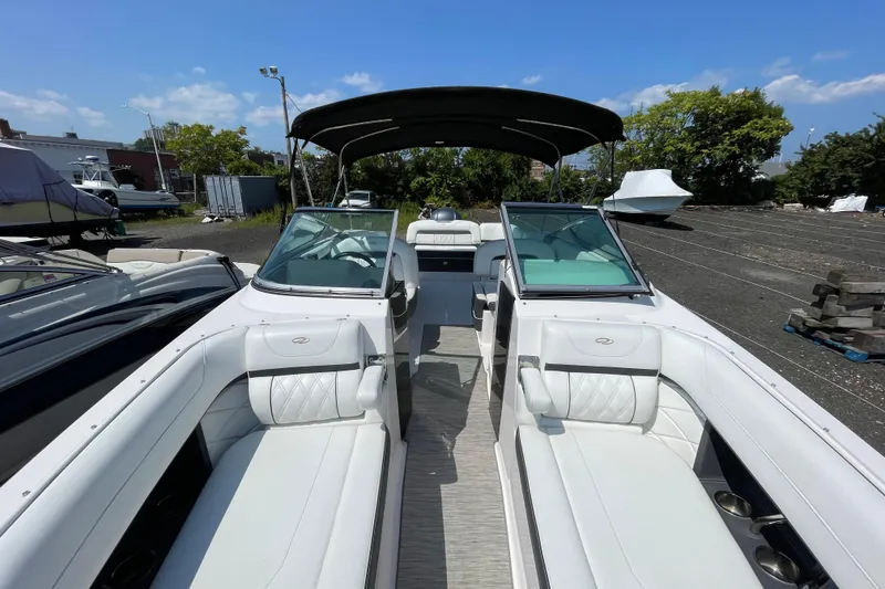 Slide: The Image of 2018 Regal 26 OBX boat with white interior and canopy, parked outdoors. - 16