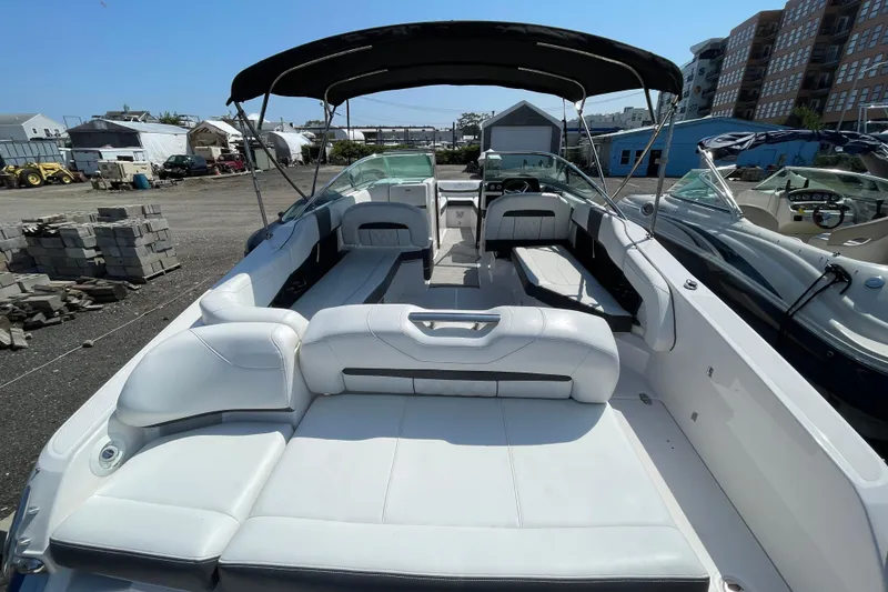 Slide: The Image of 2018 Regal 26 OBX boat with spacious seating and canopy in a marina setting. - 3