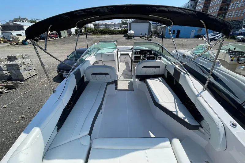 Slide: The Image of 2018 Regal 26 OBX boat with spacious seating and canopy in a marina setting. - 4
