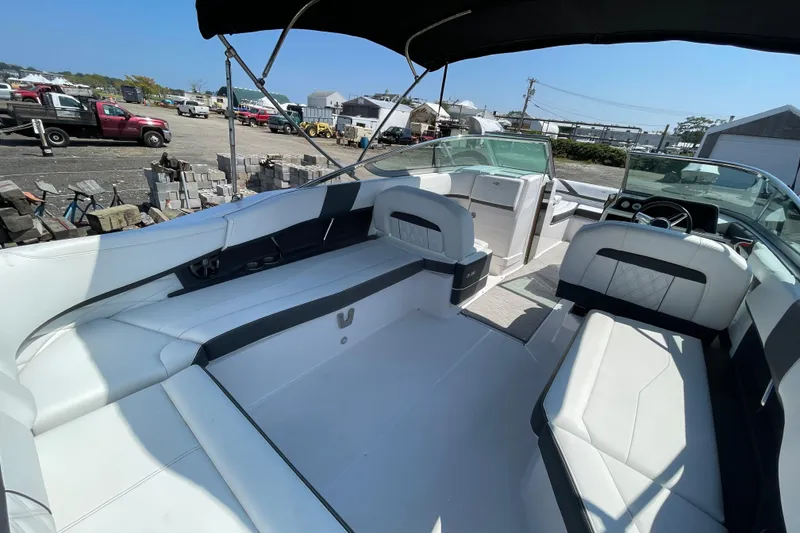 Slide: The Image of 2018 Regal 26 OBX boat interior with white seating and black accents under a canopy. - 6