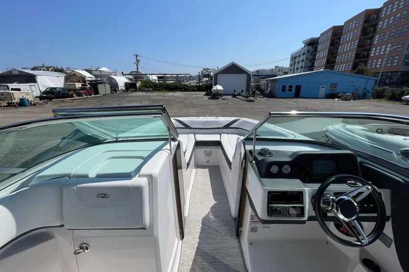 Slide: The Image of 2018 Regal 26 OBX boat interior with steering wheel and dashboard, parked in a marina. - 8