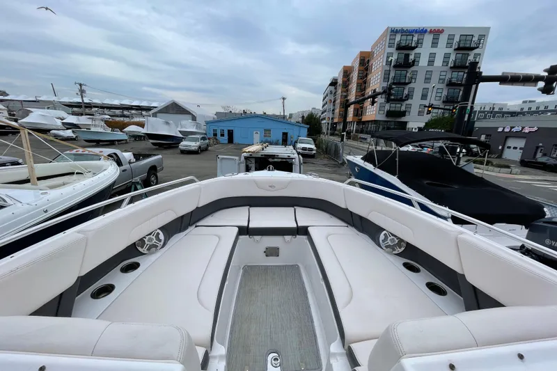 Slide: The Image of 2017 Chaparral 307 SSX boat interior at a marina with surrounding buildings. - 10