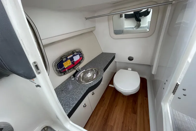 Slide: The Image of 2017 Chaparral 307 SSX boat bathroom with sink, toilet, and wood flooring. - 7