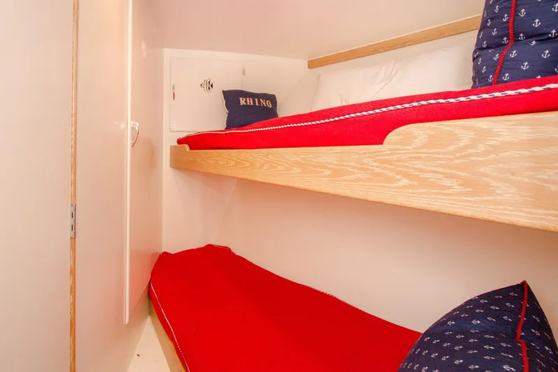 Slide: The Image of Cozy bunk beds with red bedding in a 1958 Rybovich 54 Yachtfish cabin. - 10