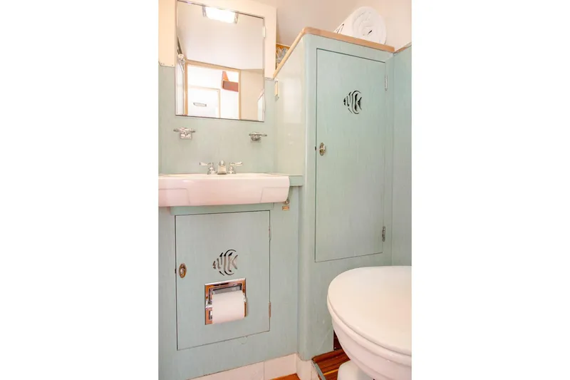Slide: The Image of Vintage 1958 Rybovich 54 Yachtfish bathroom with light blue cabinetry and fish cutout design. - 12