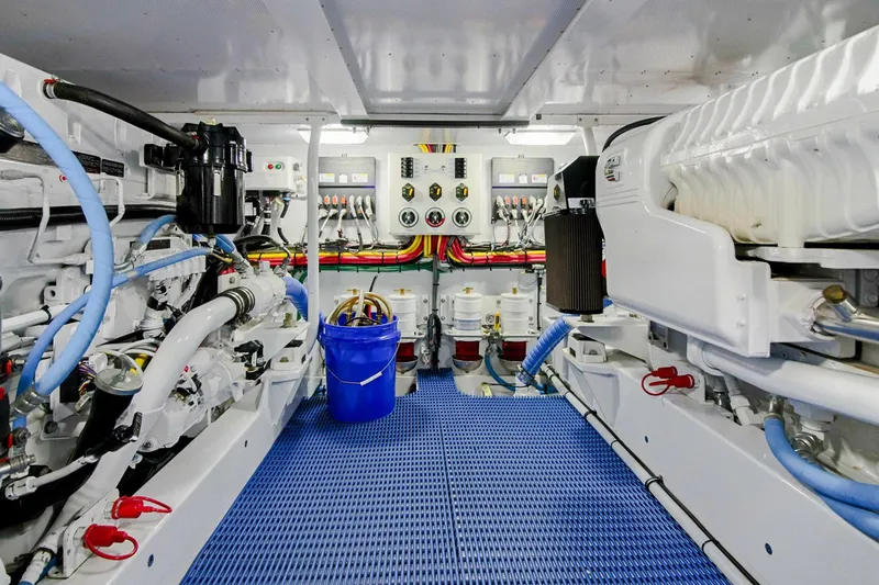 Slide: The Image of Engine room of 1958 Rybovich 54 Yachtfish, featuring modern equipment and blue flooring. - 19